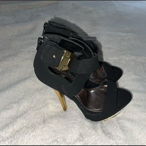Black platform with a gold heal and buckle